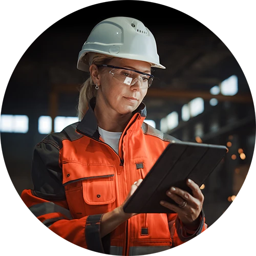 Woman technician in hard hat looking at tablet