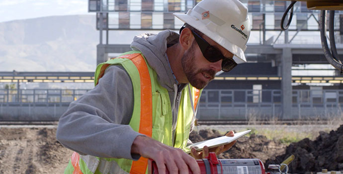 Graniterock field worker inspecting safety device with tablet