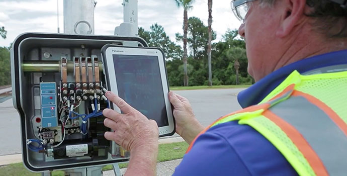 Utility technician using tablet to inspect equipment