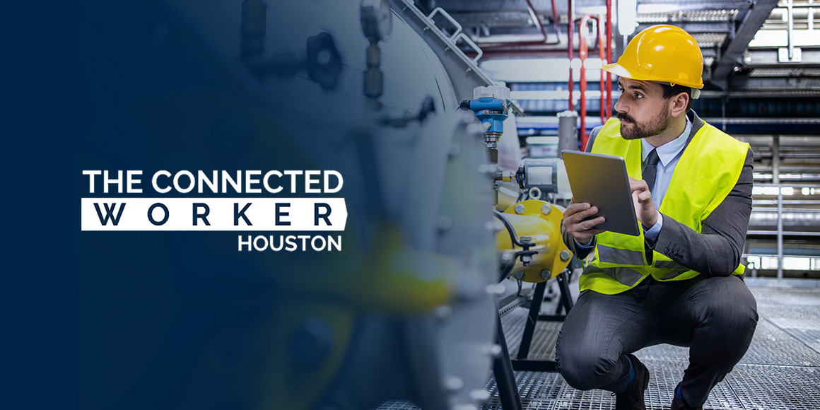 A focused engineer in a yellow hard hat and reflective vest using a tablet at an industrial plant, representing a 'Connected Worker in Houston' for enhanced field communication and productivity.